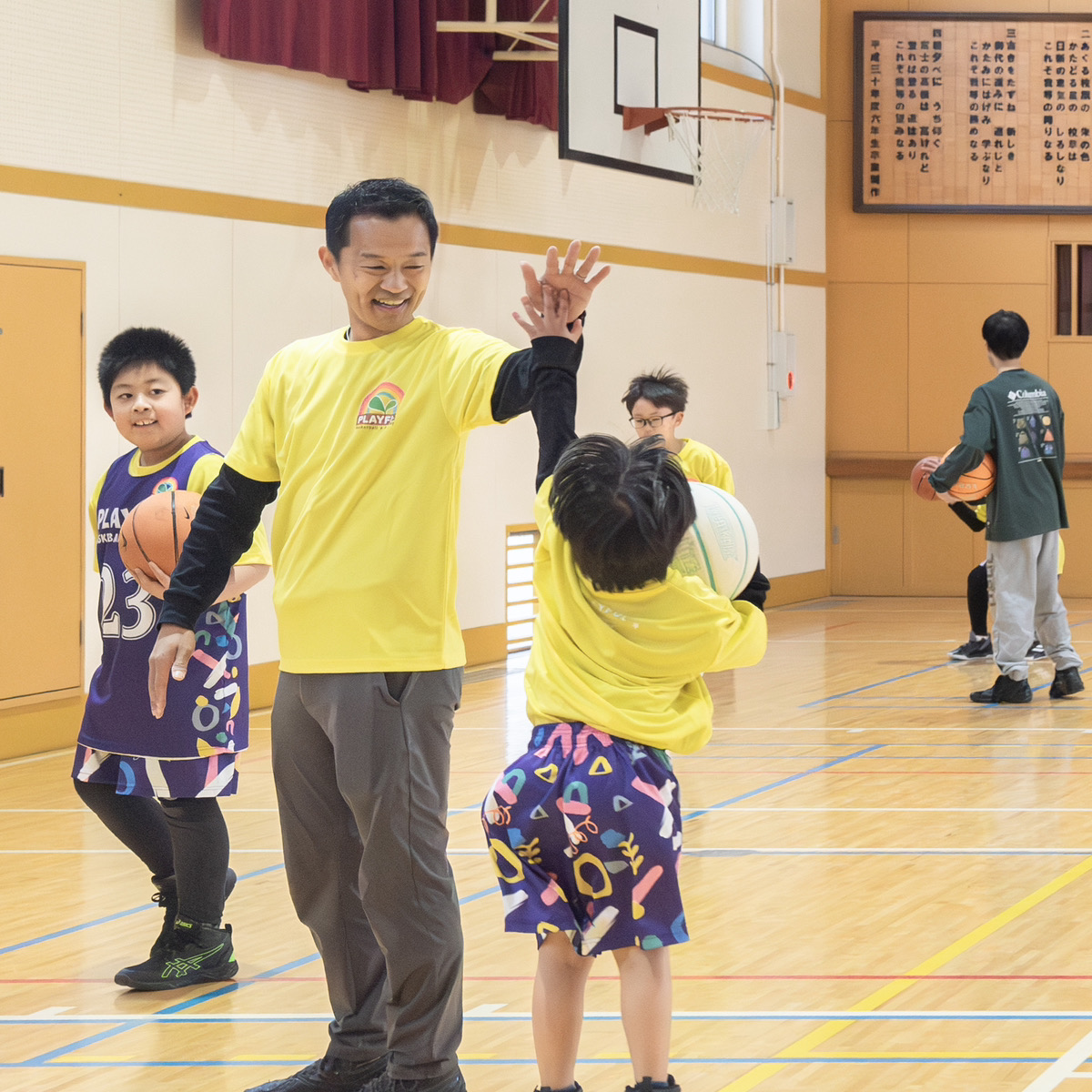 コーチとハイタッチする子ども