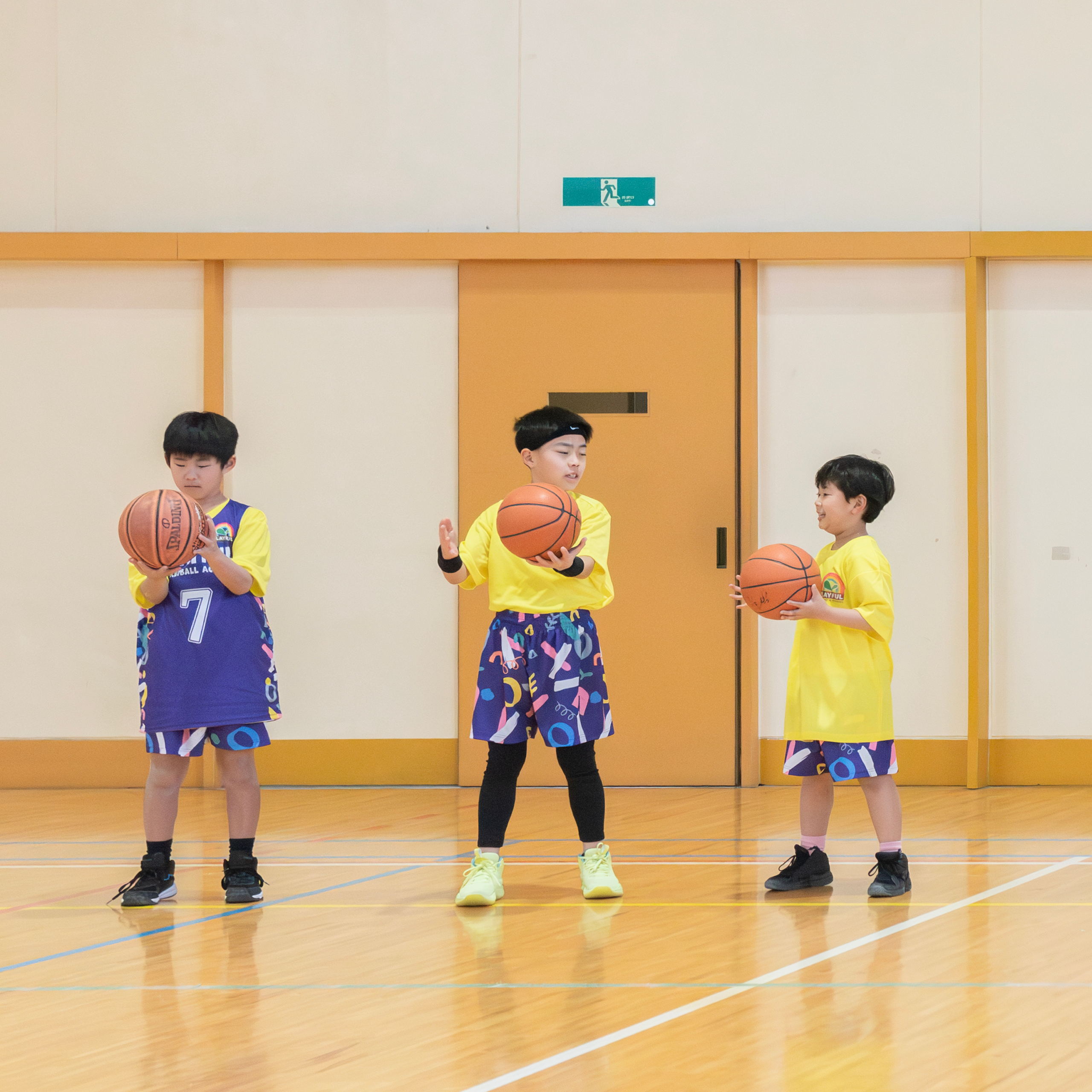 ボールを持って立つ子ども3人